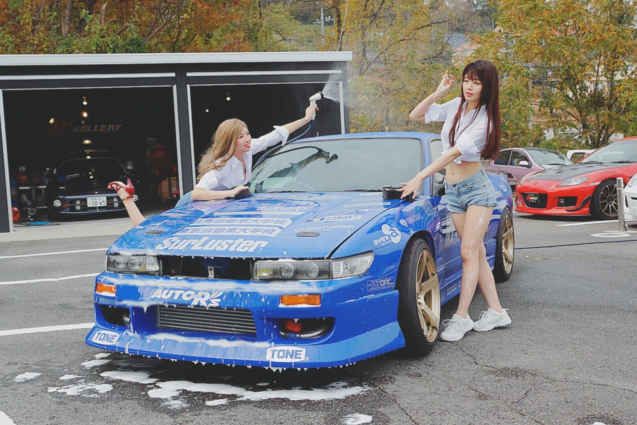 2girls asian blonde_hair blue_car blue_shorts brown_hair car cosplay_photo denim denim_shorts grey_footwear high_heels initial_d leaning_forward leaning_to_the_side mayamelo5 mazda mazda_rx-8 midriff motor_vehicle multiple_girls navel nissan nissan_180sx nissan_sileighty nissan_silvia nissan_silvia_s13 parted_lips photo_(medium) red_car red_footwear red_lips satou_mako sayuki_(initial_d) shoes shorts smile sneakers soap tree vehicle_focus washing_vehicle yuki_(bigbong)