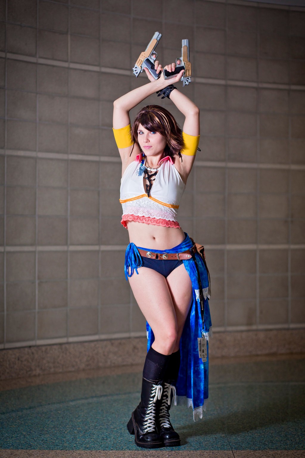 armpits arms_up boots brown_hair cosplay final_fantasy final_fantasy_x final_fantasy_x-2 gun heterochromia highres jsica_(cosplay_deviants) midriff navel photo_(medium) platform_boots weapon yuna