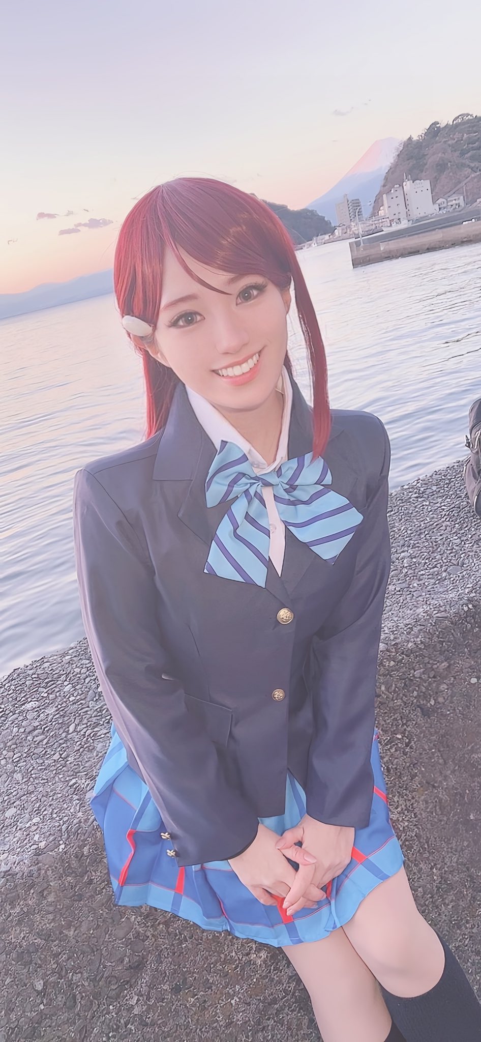 1girl beach cosplay cosplay_photo honamen_cos long_hair looking_at_viewer love_live! love_live!_sunshine!! outdoors photo_(medium) red_hair sakurauchi_riko school_uniform sitting sky smile water yellow_eyes