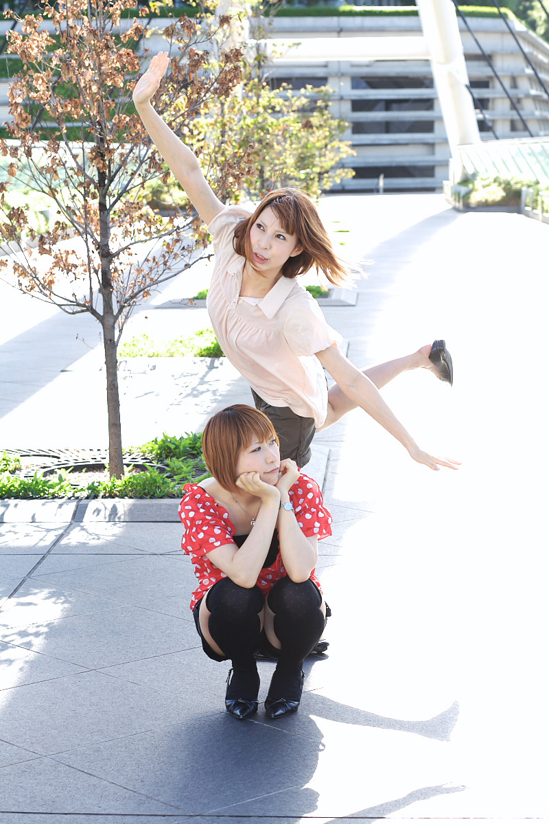 2girls ari_(model) asian black_legwear black_shorts brown_hair chippi cosplay dyed_hair female_focus highres long_hair multiple_girls outdoors photo_(medium) polka_dot polka_dot_shirt shirt shoes short_hair shorts squatting standing standing_on_one_leg thighhighs tree