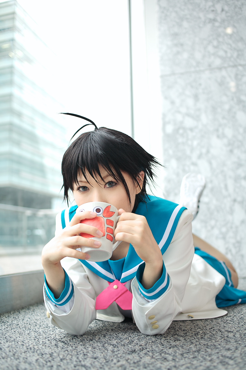 1girl ahoge asian blue_eyes chippi coffee_mug color_contacts cosplay cup female_focus highres idolmaster idolmaster_xenoglossia indoors kikuchi_makoto kikuchi_makoto_(cosplay) looking_at_viewer lying mug on_stomach photo_(medium) school_uniform serafuku short_hair solo