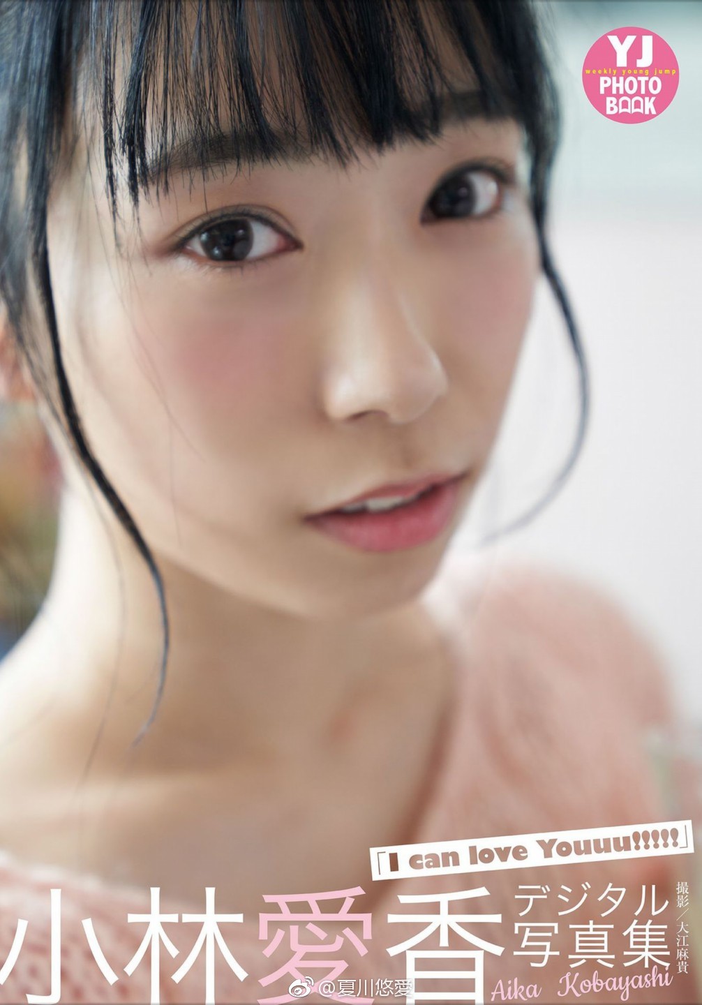 1girl black_hair earrings english_text hair_bun indoors japanese_(nationality) japanese_text jewelry kobayashi_aika looking_at_viewer makeup photo_(medium) pink_sweater short_hair sweater voice_actor