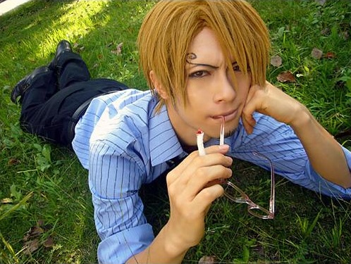 1boy blonde_hair blue_shirt collared_shirt cosplay glasses hair_over_one_eye hand_rest lowres male_focus one_piece photo_(medium) sanji_(one_piece) sanji_(one_piece)_(cosplay) shirt solo