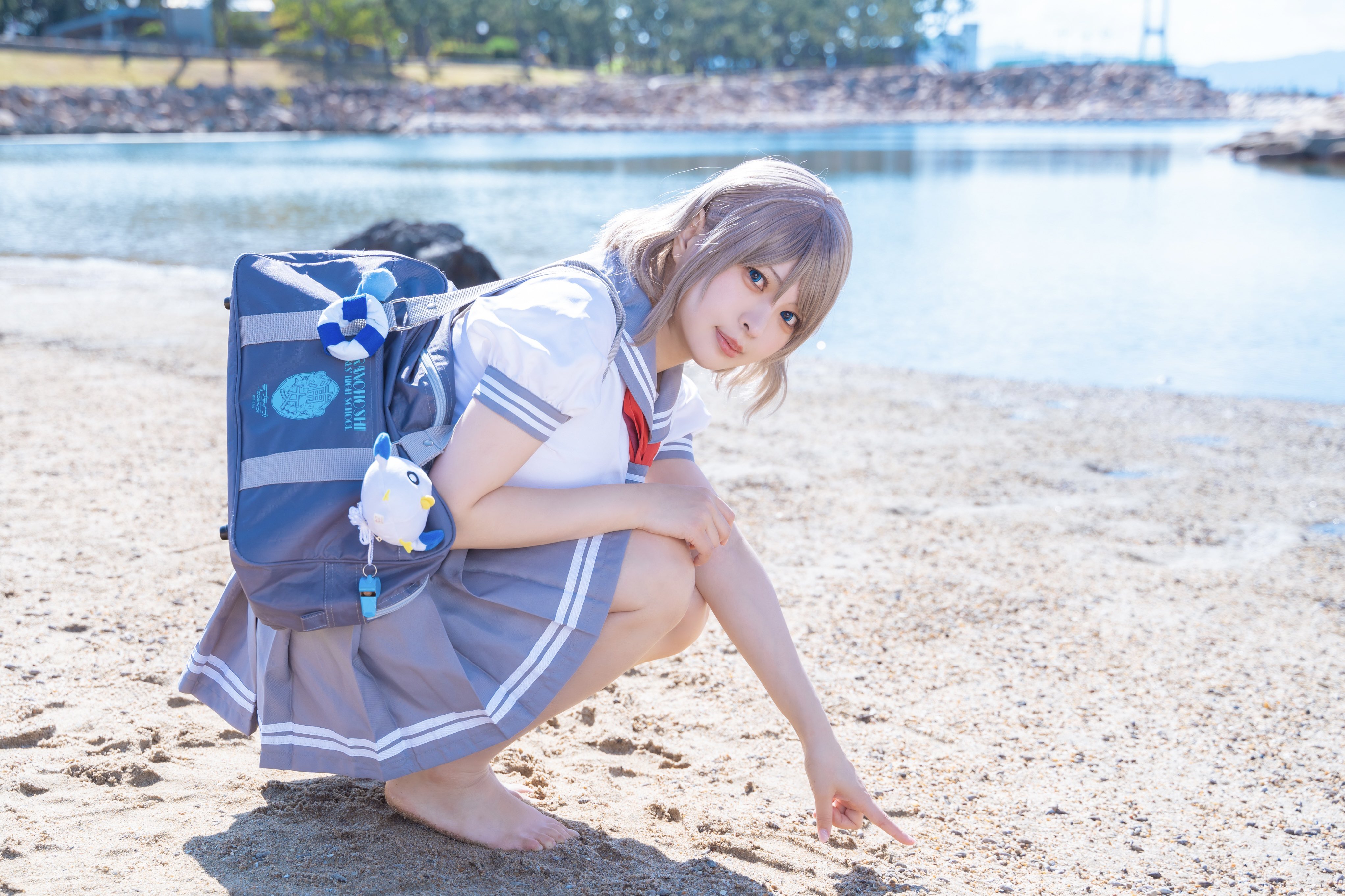 1girl absurdres beach blue_eyes brown_hair cosplay cosplay_photo grey_hair highres love_live! love_live!_sunshine!! outdoors photo_(medium) real_life sailor_collar sand solo uranohoshi_school_uniform watanabe_you