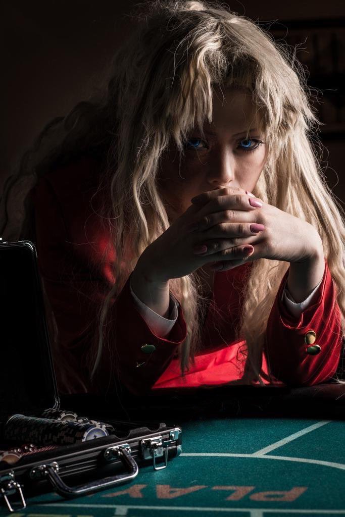 1girl 2024 arms_up backlighting balalaika_(black_lagoon) balalaika_(black_lagoon)_(cosplay) black_lagoon blue_eyes commentary cosplay cosplay_photo female_focus fingernails indoors jacket japanese_(nationality) leaning_forward long_fingernails long_hair long_sleeves looking_at_viewer messy_hair mole mole_under_eye own_hands_clasped photo_(medium) ponytail real_life red_jacket red_nails scar scar_on_face shaded_face suitcase t3223umi table upper_body v-shaped_eyebrows very_long_hair
