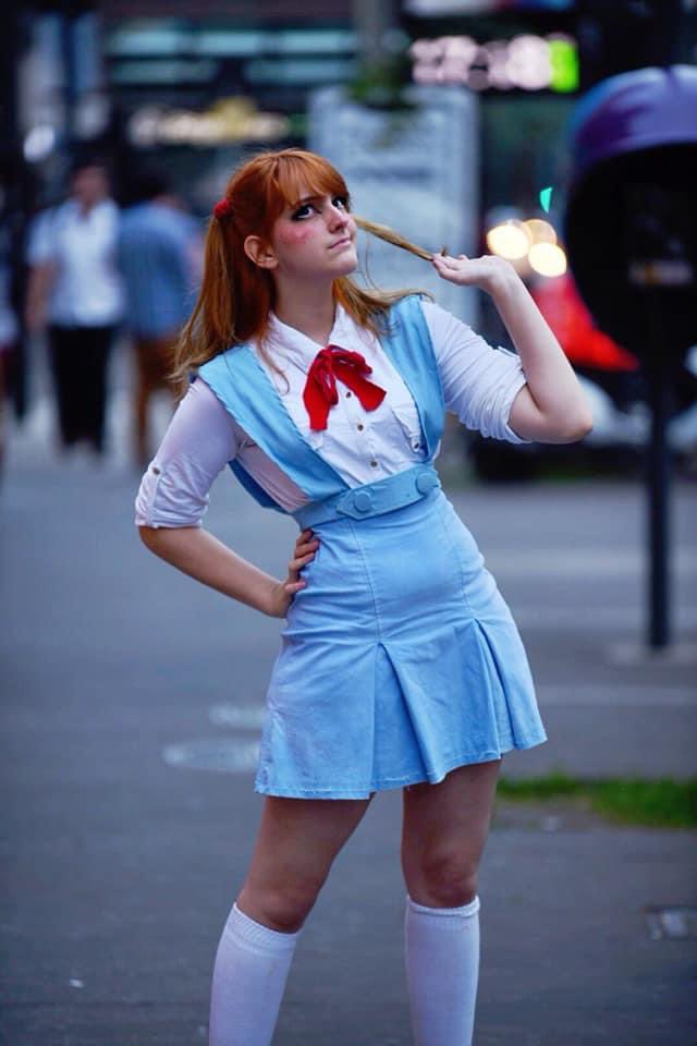 1girl bag blue_eyes brazilian_(nationality) brown_hair cosplay freckles hand_in_own_hair hand_on_own_hip interface_headset_(evangelion) light_smile lips looking_up memepantazis neon_genesis_evangelion photo_(medium) road school_uniform souryuu_asuka_langley souryuu_asuka_langley_(cosplay) standing street tokyo-3_middle_school_uniform twintails two_side_up wide_hips