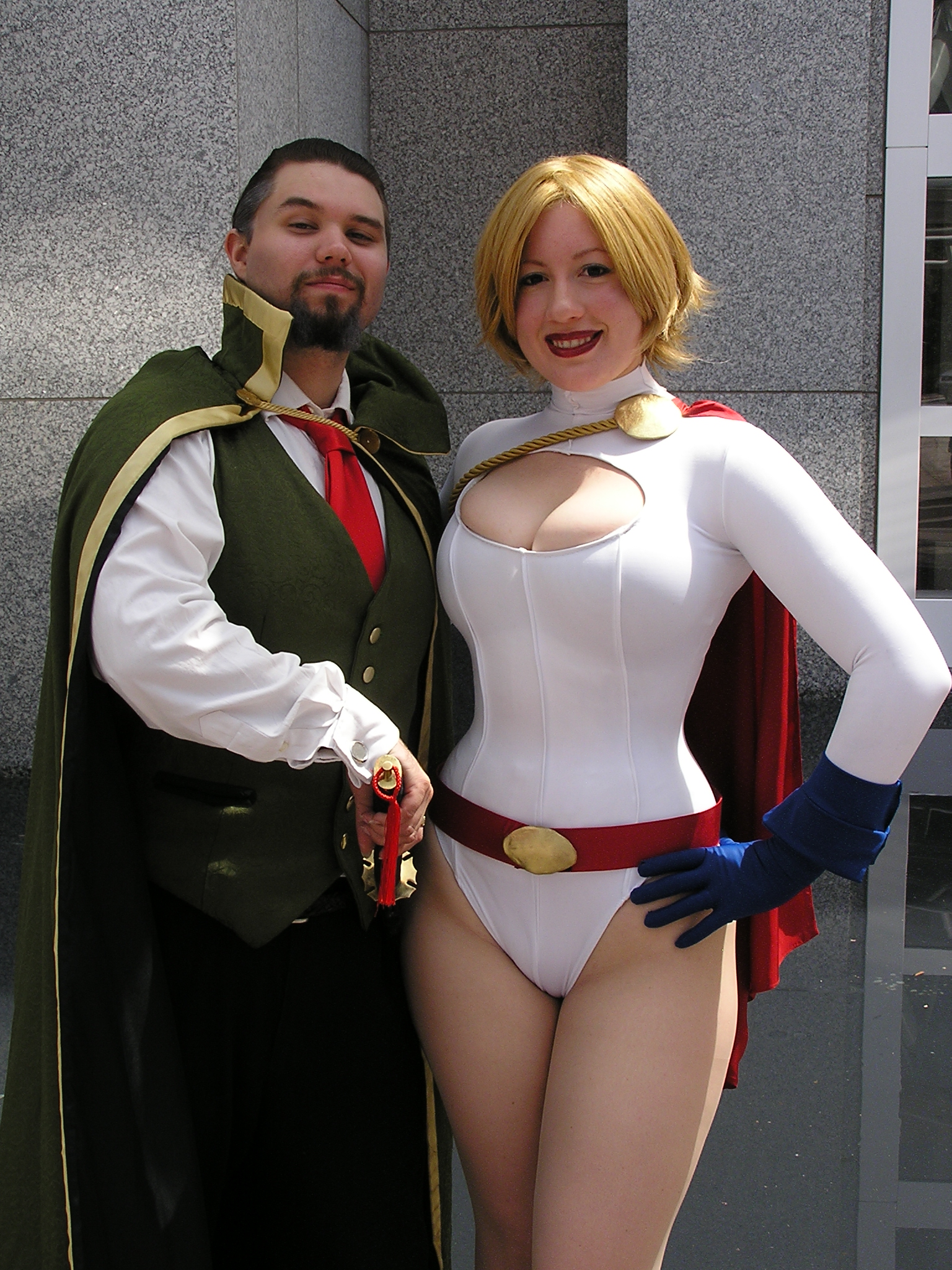 1boy 1girl belt blonde_hair breasts cape cleavage cleavage_cutout clothing_cutout cosplay dc_comics gloves highres leotard photo_(medium) power_girl power_girl_(cosplay)