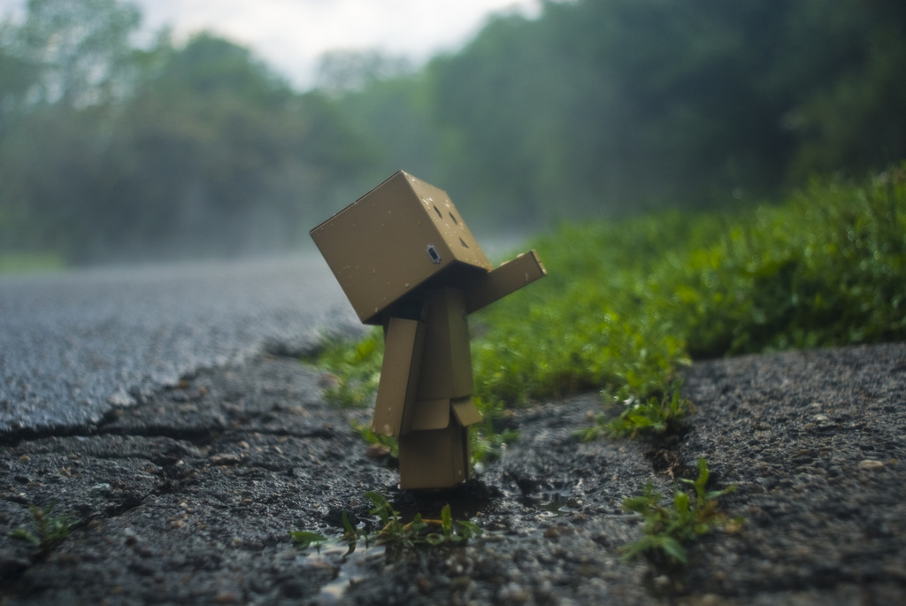 arielle_nadel azuma_kiyohiko box cardboard_box danboo figure full_body minimized no_humans outdoors outstretched_arm photo_(medium) road source_request standing switch toy water wet yotsubato!