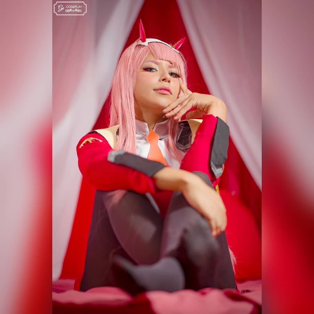 1girl blue_eyes cosplay curtains darling_in_the_franxx geisi jacket long_hair looking_at_viewer pantyhose pink_hair real_life solo zero_two_(darling_in_the_franxx)