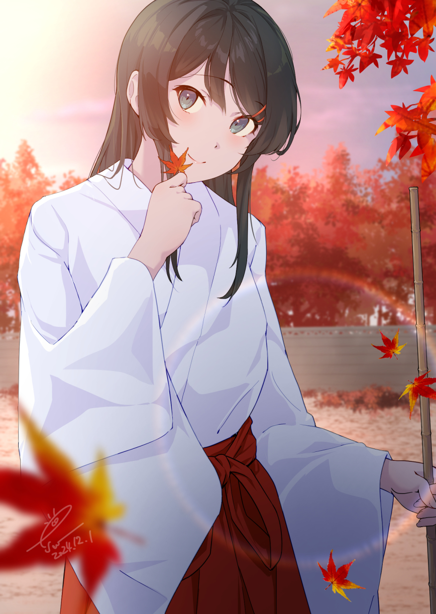 1girl bamboo_shoot black_hair blue_eyes commentary_request esw_artca falling_leaves hair_between_eyes hakama highres holding holding_leaf holding_staff japanese_clothes kimono kosode leaf light_blush long_hair looking_at_viewer maple_leaf miko red_hakama sakurajima_mai seishun_buta_yarou smile staff white_kimono