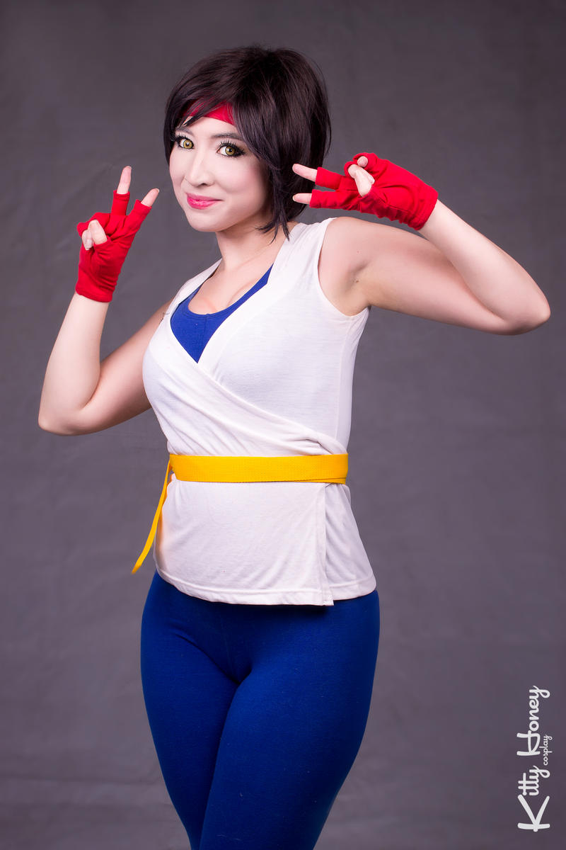 1girl brown_hair cosplay cosplay_photo female_focus fingerless_gloves gloves headband highres kitty-honey looking_at_viewer photo_(medium) real_life red_gloves red_headband ryuuko_no_ken smile snk solo spandex the_king_of_fighters yuri_sakazaki yuri_sakazaki_(cosplay)