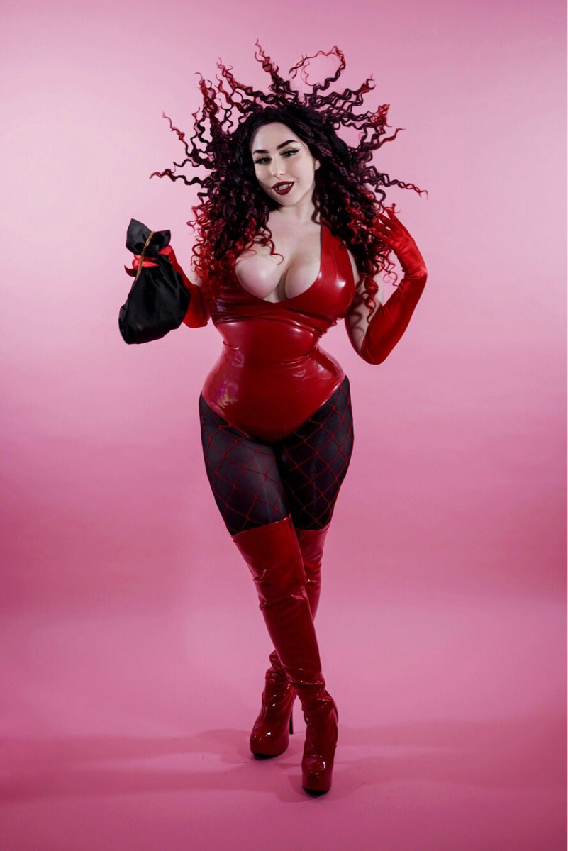 1girl bag black_eyeshadow blush_(makeup) boots breasts cartoon_network cleavage clenched_teeth collarbone cosplay cosplay_photo crossed_legs curly_hair elbow_gloves eyelashes eyeliner eyeshadow female_focus fishnets gloves green_eyes hand_in_own_hair hanna-barbera high_heels highres large_breasts latex latex_boots latex_gloves latex_legwear latex_leotard leotard lips lipstick long_hair makeup photo_(medium) pink_background platform_boots platform_footwear platform_heels png_conversion powerpuff_girls red_boots red_gloves red_hair red_leotard red_lips red_thighhighs sedusa sedusa_(cosplay) shadow smile solo source_request standing tagme teeth thejulietttemichele thick_thighs thighhighs thighs warner_bros wide_hips wig