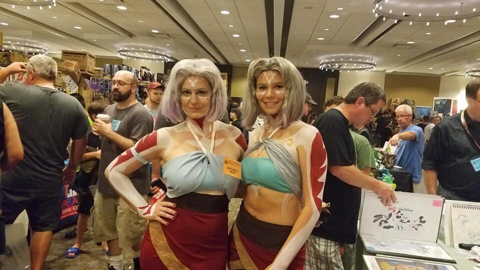 2girls artist_request cosplay godzilla_(series) grey_hair houtua jennifer_lynn_larsen looking_at_viewer maina miana multiple_girls real_life siblings sisters smile tribal twins