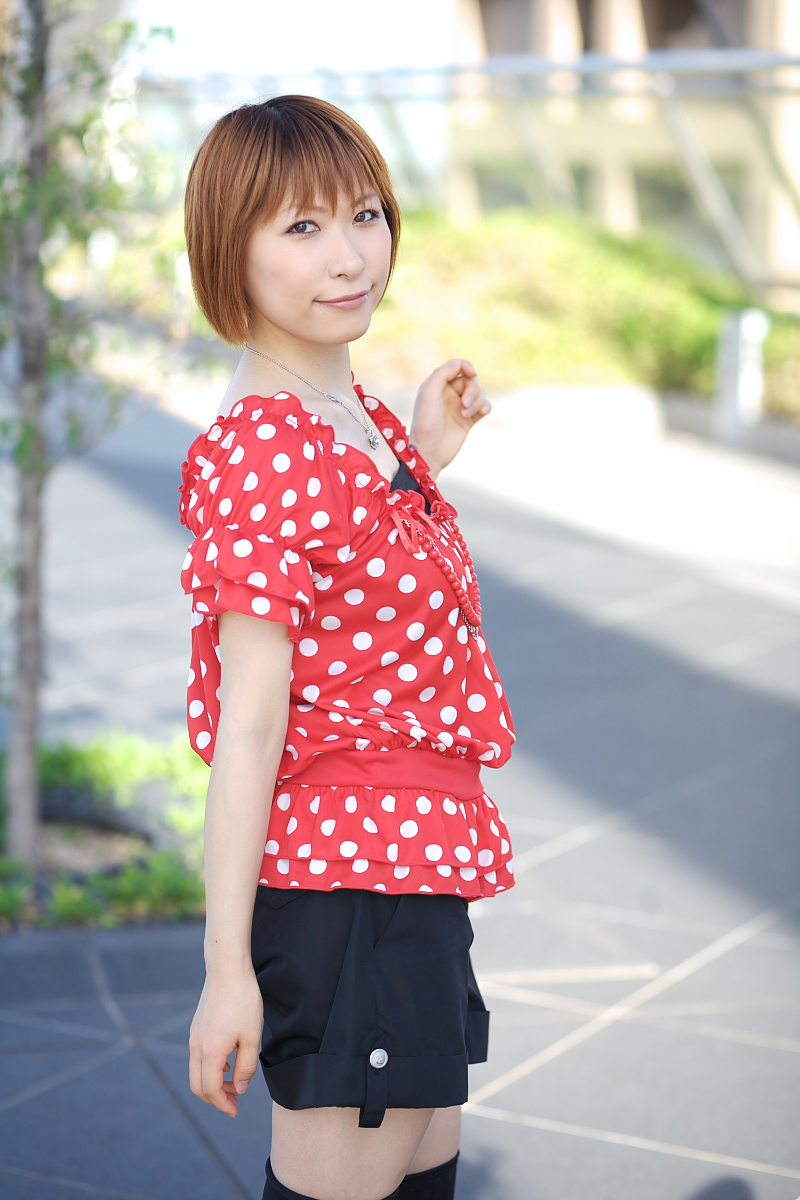 1girl asian black_shorts chippi female_focus highres looking_at_viewer outdoors photo_(medium) polka_dot polka_dot_shirt shirt short_hair shorts solo thighhighs