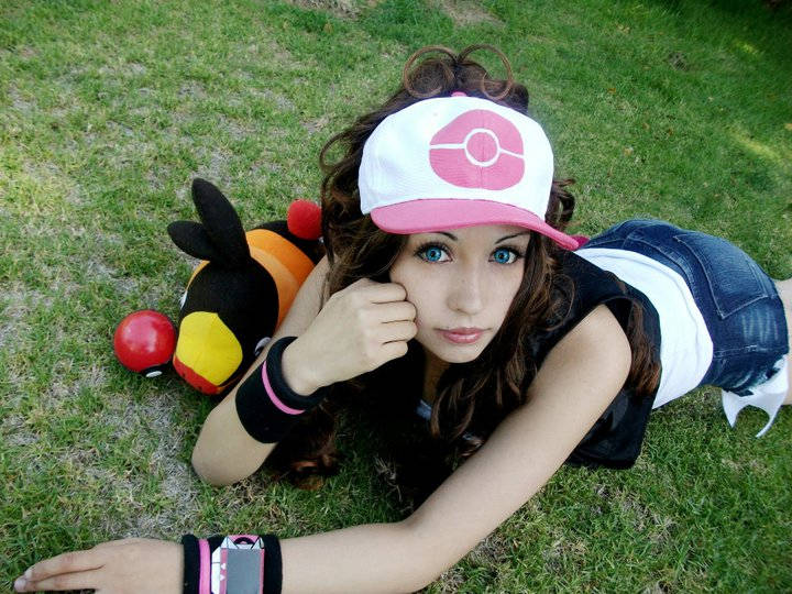 1girl baseball_cap blue_eyes brown_hair cosplay cosplay_photo female_focus gen_5_pokemon hat high_ponytail hilda_(pokemon) hilda_(pokemon)_(cosplay) long_hair looking_at_viewer lying nintendo on_stomach outdoors photo_(medium) pink_hat poke_ball poke_ball_(basic) pokemon pokemon_bw ponytail real_life solo tepig two-tone_headwear zettai_cos