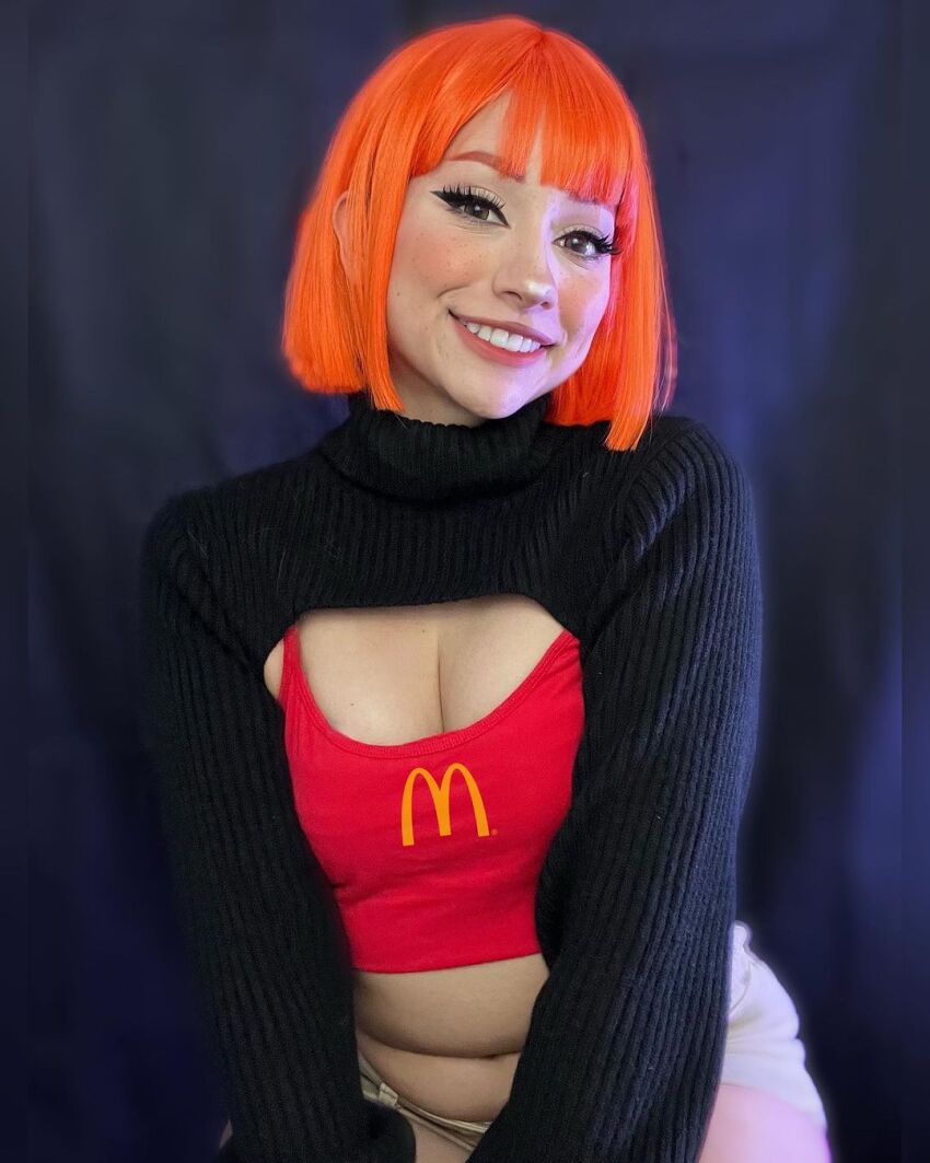 1girl black_background breasts brown_eyes cleavage cosplay female_focus highres indoors looking_at_viewer mcdonald&#039;s mexican_(nationality) mother_(yoru_mac) mother_(yoru_mac)_(cosplay) navel orange_hair photo_(medium) short_hair simple_background sitting small_breasts smile solo taliverse teeth yoru_mac