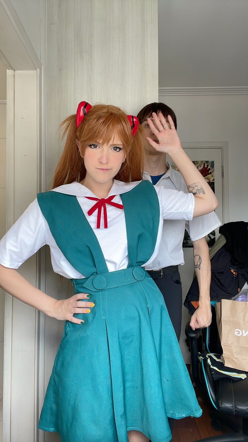 1boy 1girl blue_eyes brazilian_(nationality) brown_hair cosplay covering_face hairpods hand_on_own_hip highres ikari_shinji ikari_shinji_(cosplay) interface_headset_(evangelion) lips looking_at_viewer memepantazis neon_genesis_evangelion photo_(medium) photo_(object) souryuu_asuka_langley souryuu_asuka_langley_(cosplay) standing twintails two_side_up
