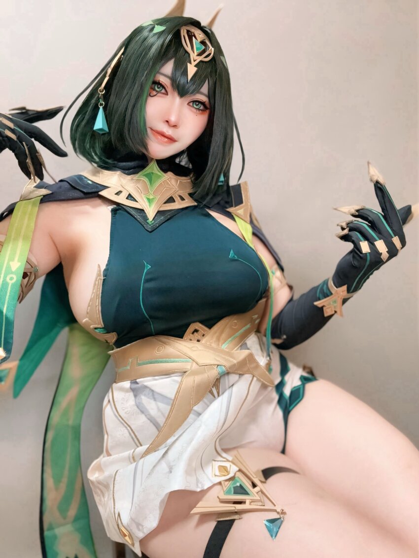 1girl absurdres ancient_egyptian_clothes armpit_crease breasts closed_mouth cosplay_photo earpiece elbow_gloves eye_tattoo fake_claws genshin_impact gloves green_eyes green_hair green_shirt highres large_breasts looking_at_viewer medium_hair mole mole_under_eye nefer_(genshin_impact) nueyama_nueccha photo_(medium) shirt sitting skirt solo tattoo thigh_strap usekh_collar white_skirt