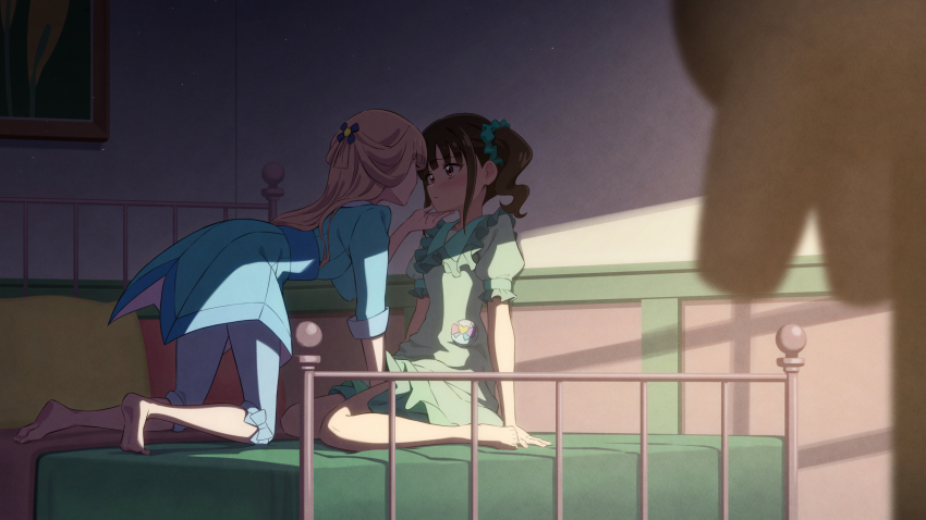 2girls blonde_hair blue_dress blue_pants blurry blurry_foreground blush brown_hair closed_mouth commentary dress green_dress half_updo hand_on_another&#039;s_chin highres indoors light_particles long_hair looking_at_another multiple_girls nekoyashiki_mayu nekoyashiki_yuki nuenue on_bed pants pink_eyes precure red_eyes side_ponytail wonderful_precure! yuri