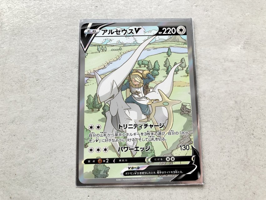 1boy arceus backpack bag blonde_hair boots bridge brown_bag card card_(medium) character_name character_print closed_eyes commentary_request gen_4_pokemon grass hair_over_one_eye hat highres jumpsuit legendary_pokemon male_focus mythical_pokemon nintendo official_style pokemon pokemon_legends:_arceus pokemon_tcg pokeyugami riding riding_pokemon river short_hair sitting smile tree volo_(pokemon) water