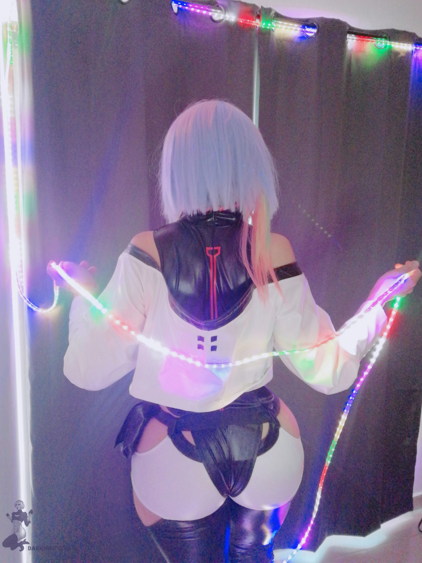 1boy absurdres androgynous arm_support ass bare_shoulders bed black_leotard cosplay cowboy_shot curvy cyberpunk_(series) cyberpunk_edgerunners darkwaifutrap earrings hair_ribbon heattech_leotard highleg highleg_leotard highres huge_ass jacket jewelry leotard long_hair long_sleeves lucy_(cyberpunk) lucy_(cyberpunk)_(cosplay) off-shoulder_jacket off_shoulder on_bed open_clothes open_jacket parted_bangs photo_(medium) purple_hair real_life ribbon short_shorts shorts skindentation sleeveless_turtleneck_leotard solo standing trap turtleneck very_long_hair watermark white_hair white_jacket white_shorts wide_hips