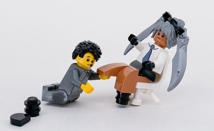 1boy 1girl black_gloves black_hair blue_archive blue_archive_the_animation blue_necktie commentary_request dark-skinned_female dark_skin formal_clothes full_body gloves grey_background grey_hair hetero highres interracial iori_(blue_archive) lego lego_(medium) lego_minifig moko_(legodou) necktie on_chair photo_(medium) scene_reference sensei_(blue_archive) sensei_(blue_archive_the_animation) short_hair simple_background sitting smile tongue tongue_out unconventional_media
