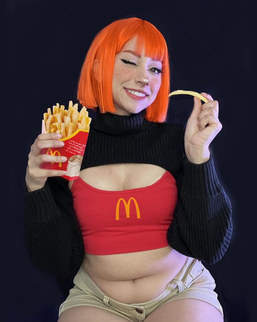 1girl black_background breasts brown_eyes cleavage cosplay female_focus food french_fries highres looking_at_viewer mcdonald&#039;s mexican_(nationality) mother_(yoru_mac) mother_(yoru_mac)_(cosplay) navel one_eye_closed orange_hair photo_(medium) short_hair simple_background sitting small_breasts smile solo taliverse teeth yoru_mac