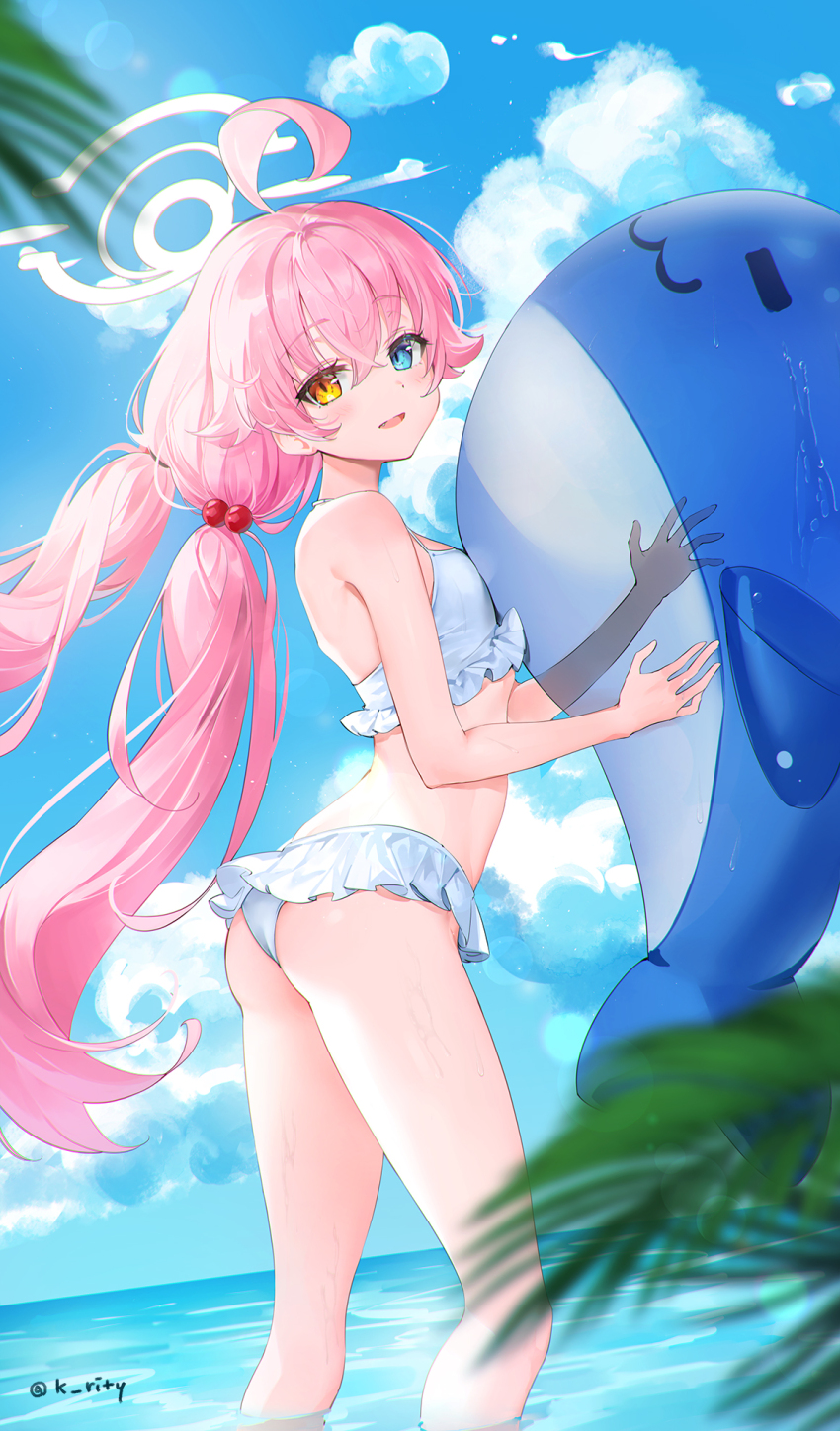 1girl bikini blue_archive blurry blurry_foreground blush breasts butt_crack commentary depth_of_field floating_hair frilled_bikini frills halo heterochromia highres hoshino_(blue_archive) hoshino_(swimsuit)_(blue_archive) inflatable_orca inflatable_toy looking_at_viewer looking_to_the_side outdoors palm_leaf pink_hair rity small_breasts smile solo swimsuit twintails wading white_bikini
