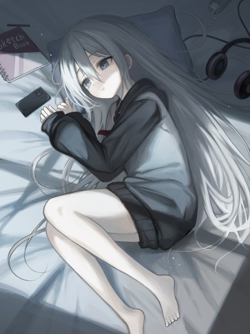 1girl absurdres barefoot bed blue_eyes cellphone commentary_request headphones highres hood hood_down hoodie kkamkkam lying on_side parted_lips pencil phone pill pill_bottle pillow project_sekai sketchbook sleeves_past_wrists smartphone solo white_hair yoisaki_kanade