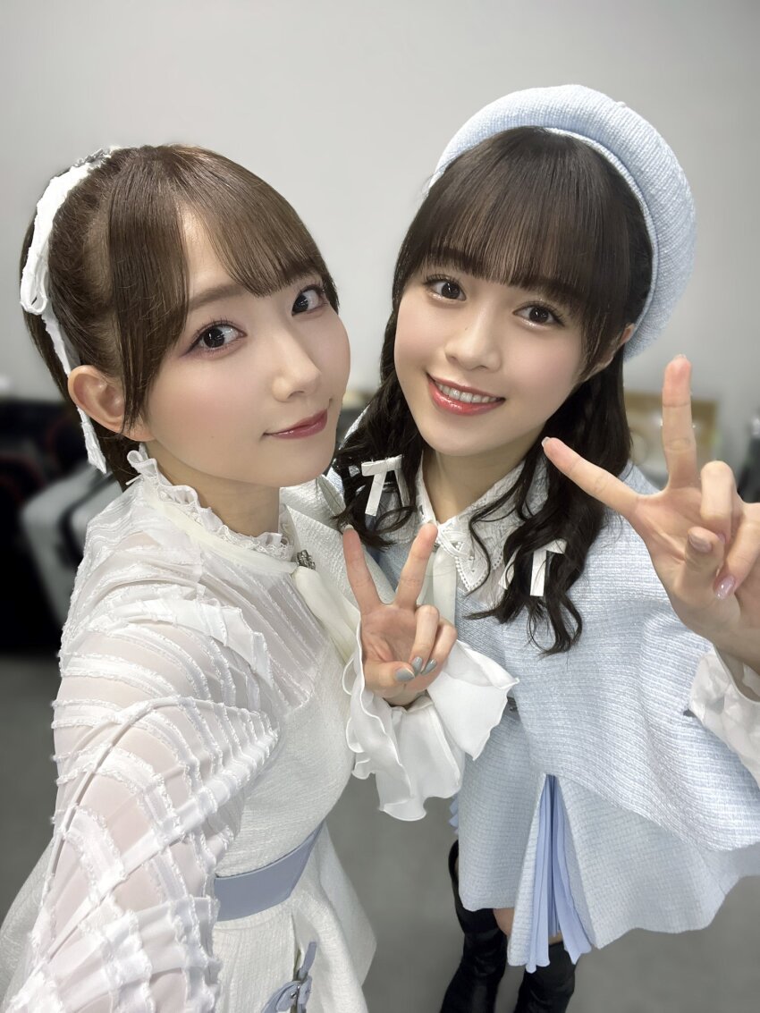 2girls aoyama_nagisa costume emori_aya highres indoors looking_at_viewer multiple_girls photo_(medium) selfie simple_background smile standing