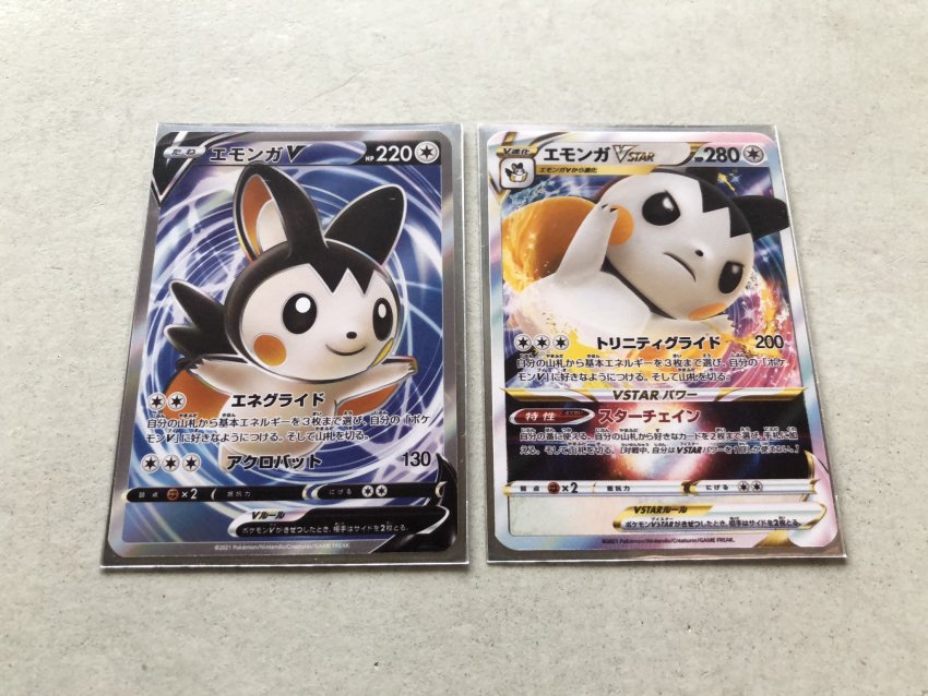 black_eyes card card_(medium) character_name character_print closed_mouth commentary_request emolga frown gen_5_pokemon highres nintendo official_style outstretched_arms pokemon pokemon_tcg pokeyugami smile translation_request