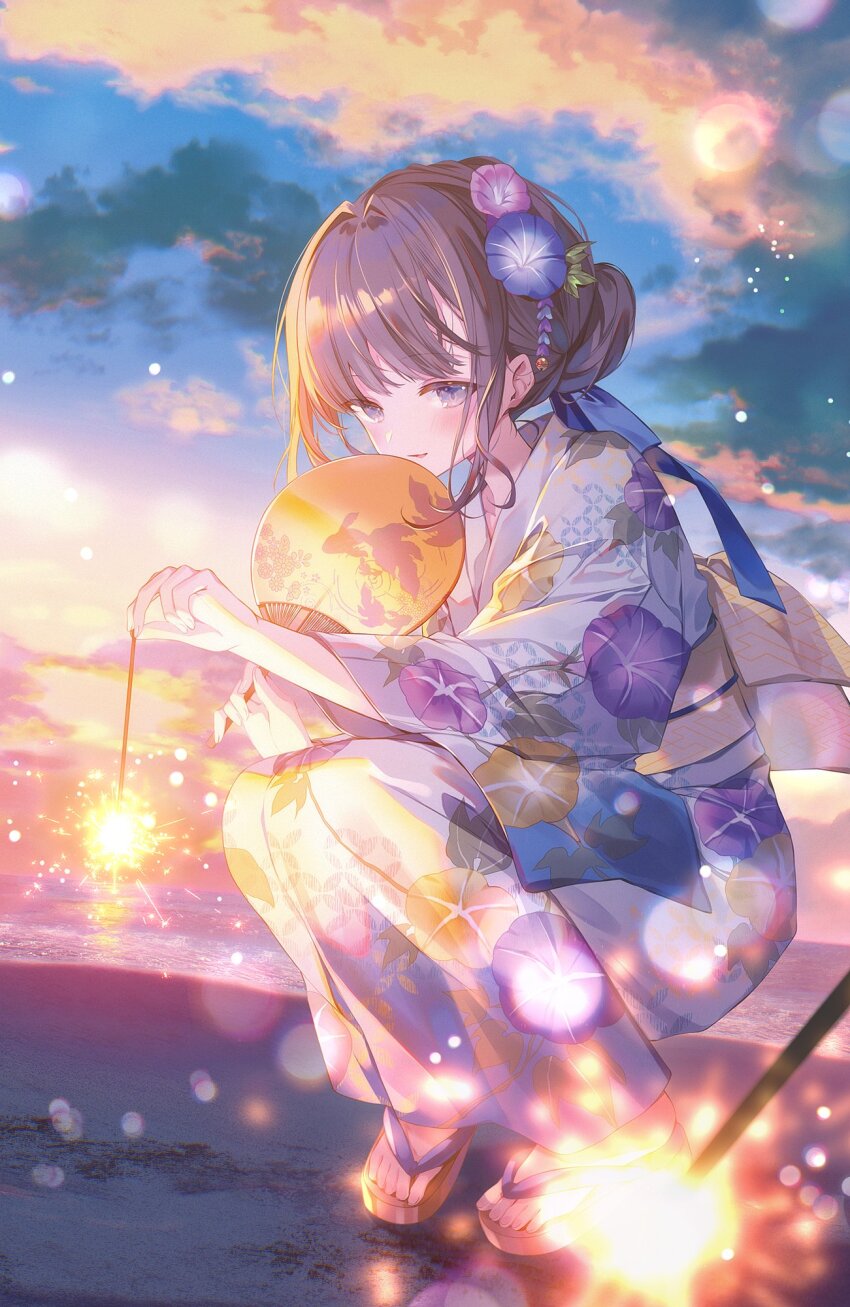1girl beach blush brown_hair commentary_request dusk fireworks flower grey_eyes hair_flower hair_ornament hand_fan highres horizon ibara_riato japanese_clothes kimono looking_at_viewer melonbooks original outdoors parted_lips senkou_hanabi sky smile solo sparkler squatting twilight water yukata