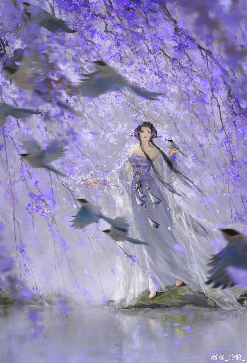 1girl absurdres barefoot bird black_hair blurry blurry_foreground dress flower flying full_body hair_flower hair_ornament highres lipstick looking_at_viewer magpie makeup open_clothes open_robe original petals purple_flower robe see-through_robe solo standing strapless strapless_dress tassel tree water willow yan_que