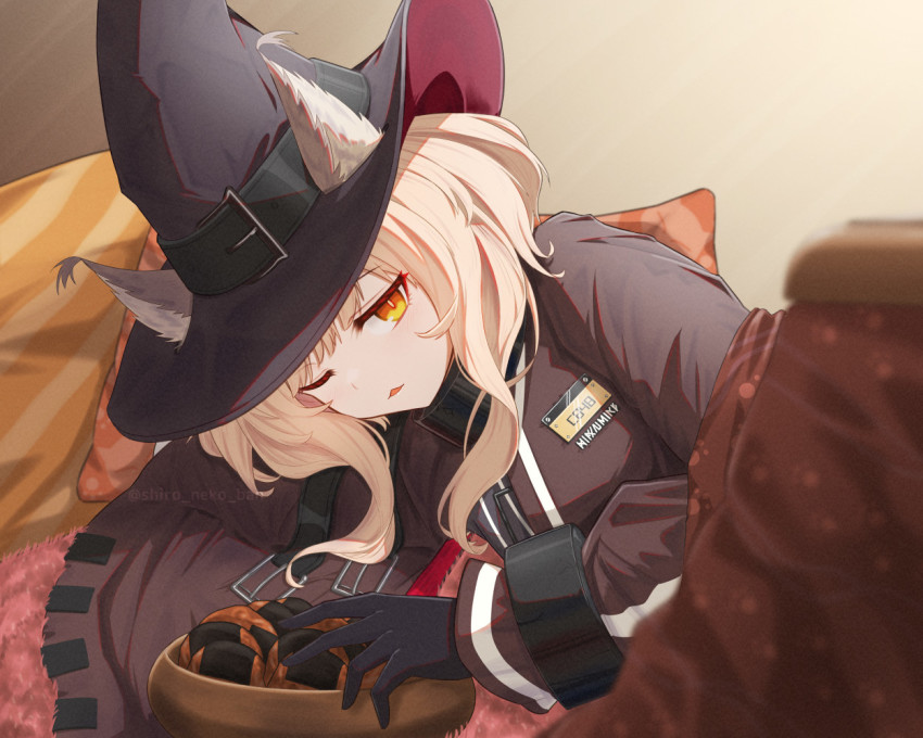 1girl animal_ears arknights black_gloves black_shirt blonde_hair cat_ears cat_girl cuffs ears_through_headwear gloves hat hat_belt haze_(arknights) kotatsu looking_at_viewer lying medium_hair on_side one_eye_closed orange_eyes parted_lips shackles shironekoban shirt solo table under_kotatsu under_table witch_hat