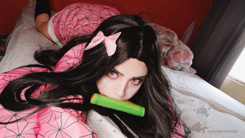1boy black_hair cosplay crossdressing darkwaifutrap highres kamado_nezuko kamado_nezuko_(cosplay) kimetsu_no_yaiba long_hair looking_at_viewer lying male_focus on_stomach photo_(medium) solo trap