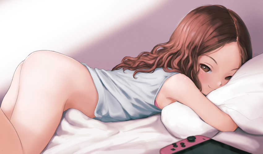 1girl ass bare_shoulders bed_sheet blush bottomless breasts brown_eyes brown_hair closed_mouth come_hither controller game_controller handheld_game_console hugging_object kuroshiro00 loli long_hair looking_at_viewer lying naughty_face nintendo nintendo_switch on_stomach original parted_bangs pillow pillow_hug seductive_smile small_breasts smile solo thighs uncensored