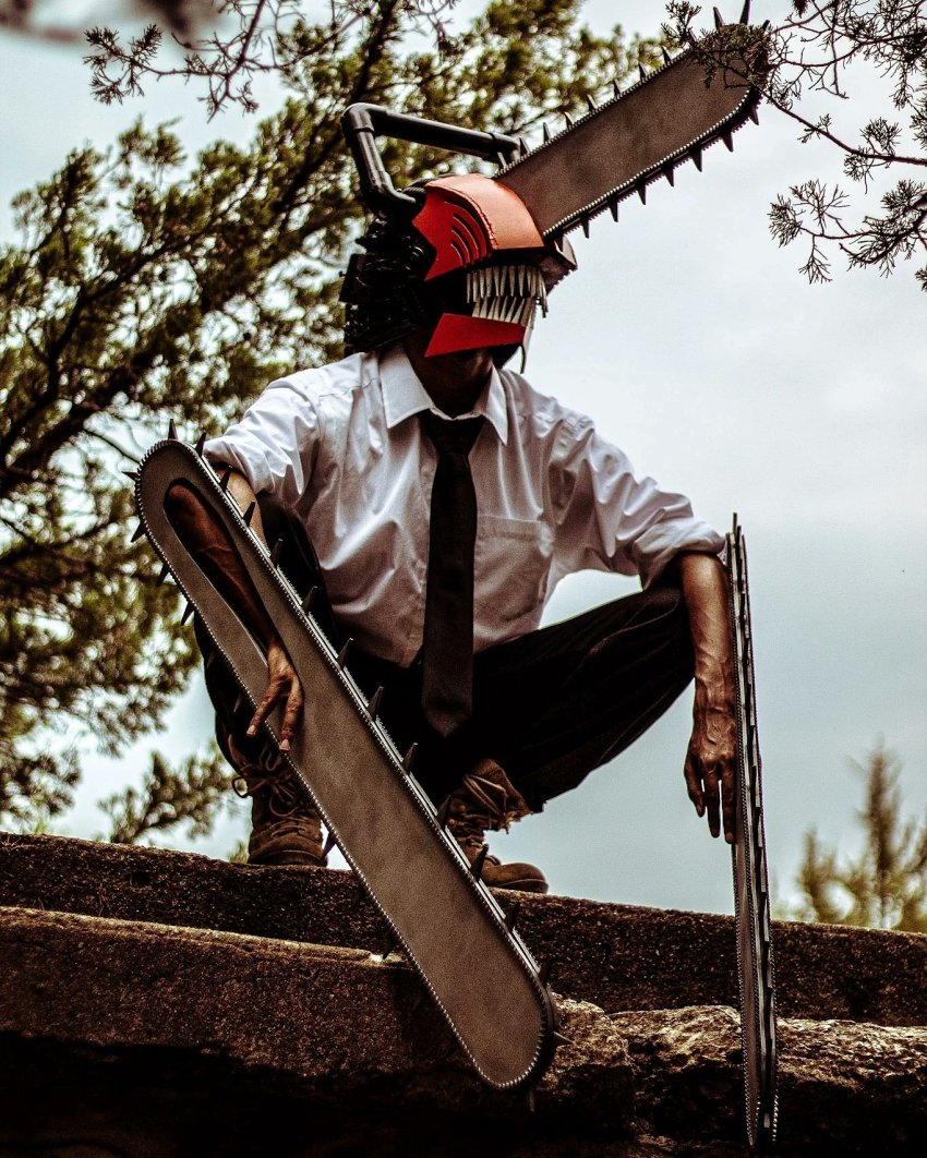 1boy black_necktie black_pants boots brown_boots chainsaw chainsaw_man collared_shirt commentary cosplay cosplay_photo denji_(chainsaw_man) denji_(chainsaw_man)_(cosplay) english_commentary highres lane_tiziu male_focus necktie pants photo_(medium) sharp_teeth shirt sky solo teeth tree white_shirt