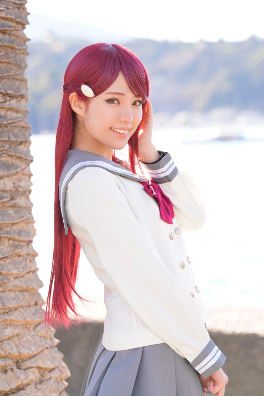 1girl blurry blurry_background cosplay cosplay_photo honamen_cos long_hair looking_at_viewer love_live! love_live!_sunshine!! outdoors photo_(medium) red_hair sakurauchi_riko school_uniform smile standing yellow_eyes