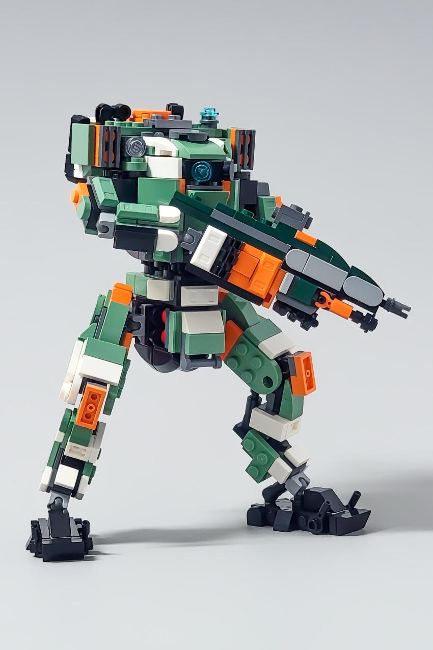 absurdres bt-7274 commentary english_commentary grey_background gun highres holding holding_gun holding_weapon lego_(medium) looking_at_viewer mecha mecha_focus no_humans one-eyed photo_(medium) rabidflea robot science_fiction shadow titan_(titanfall) titanfall_(series) titanfall_2 unconventional_media weapon