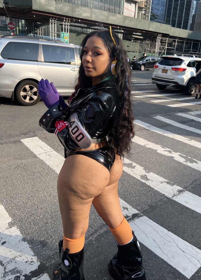 1girl ass bare_legs black_hair black_jacket black_panties car city cosplay cosplay_photo cropped_jacket crosswalk curly_hair dark-skinned_female dark_skin day from_behind gloves highres huge_ass jacket kikoblac leather leather_jacket long_hair long_sleeves looking_at_viewer looking_back motor_vehicle nico_robin nico_robin_(cosplay) nico_robin_(egghead) one_piece outdoors panties people photo_(medium) purple_gloves road street underwear