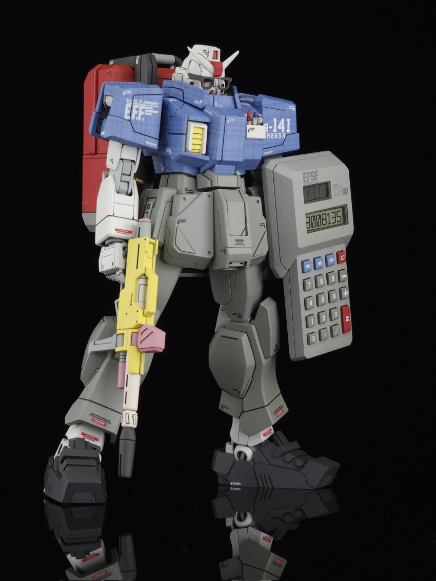 backpack bag black_background calculator dumbpla full_body glasses ground_gundam gun gundam gundam_08th_ms_team gunpla highres holding holding_gun holding_weapon mecha model_kit model_kit_(medium) no_humans photo_(medium) robot science_fiction solo unconventional_media v-fin weapon