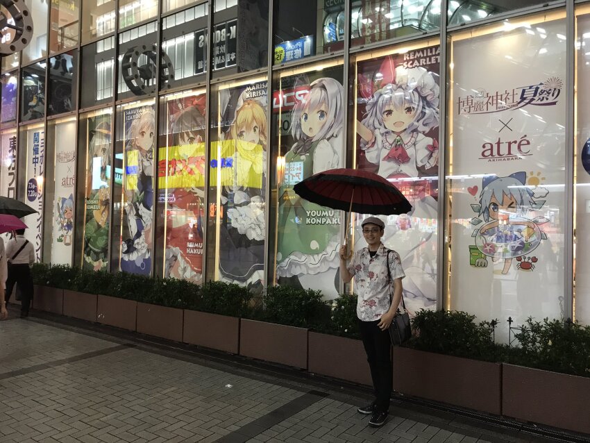 1boy 6+girls akihabara_(tokyo) apron ascot asian atre_akihabara bag black_bag black_bow black_bowtie black_hairband black_hat black_pants blouse blue_skirt blue_vest bow bowtie brown_hair character_name cirno closed_mouth cowboy_shot detached_wings floral_print frilled_apron frilled_skirt frilled_sleeves frills full_body green_hair green_skirt green_vest grey_hair grey_hat hair_bow hairband hakurei_reimu hat hat_ribbon highres hitodama_print holding holding_umbrella ice ice_wings innertube kirisame_marisa komeiji_koishi konpaku_youmu looking_at_viewer medium_hair mob_cap multiple_girls oil-paper_umbrella open_mouth outdoors pants photo_(medium) print_shirt print_skirt puffy_short_sleeves puffy_sleeves real_life red_ascot red_bow red_umbrella remilia_scarlet ribbon rose_print shirt shoes short_hair short_sleeves shoulder_bag skirt sneakers standing swim_ring tanned_cirno teeth touhou umbrella upper_teeth_only very_short_hair vest waist_apron white_apron wings witch_hat yellow_ribbon yellow_shirt zun zun_(artist)