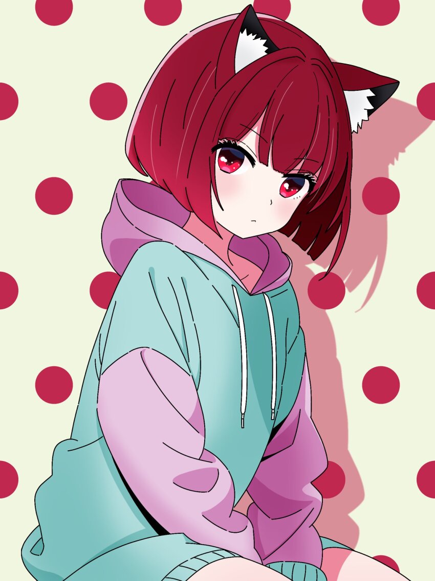 1girl animal_ears arima_kana blue_hoodie bob_cut bokutaaaa cat_ears cat_girl closed_mouth highres hood hoodie inverted_bob looking_at_viewer oshi_no_ko polka_dot polka_dot_background red_eyes red_hair short_hair sitting solo