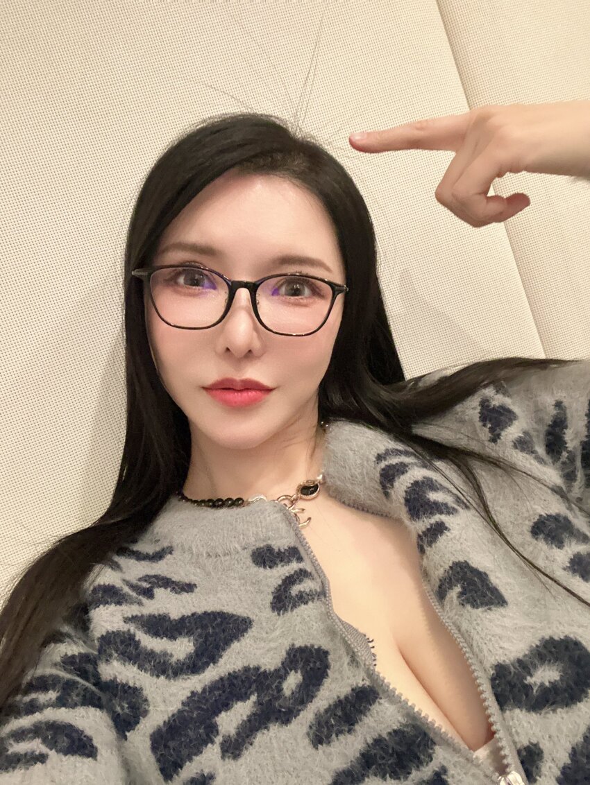 1girl animal_print asian black_hair breasts brown_eyes cleavage closed_mouth female_focus glasses highres huge_breasts indoors japanese_(nationality) jewelry leopard_print long_hair looking_at_viewer makeup necklace okita_anri photo_(medium) real_life red_lips solo