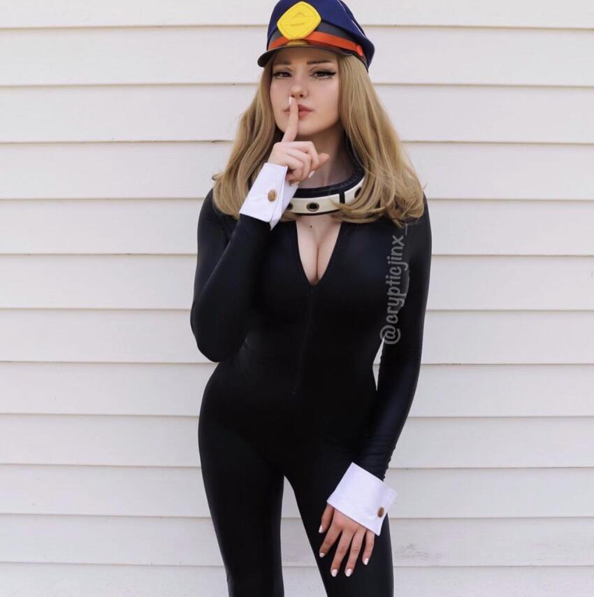 1girl black_bodysuit blonde_hair bodysuit boku_no_hero_academia breasts cleavage cosplay cosplay_photo crypticjinx female_focus finger_to_mouth hat highres instagram_username large_breasts long_hair looking_at_viewer mole mole_on_breast peaked_cap photo_(medium) real_life skin_tight solo utsushimi_kemii utsushimi_kemii_(cosplay) wrist_cuffs