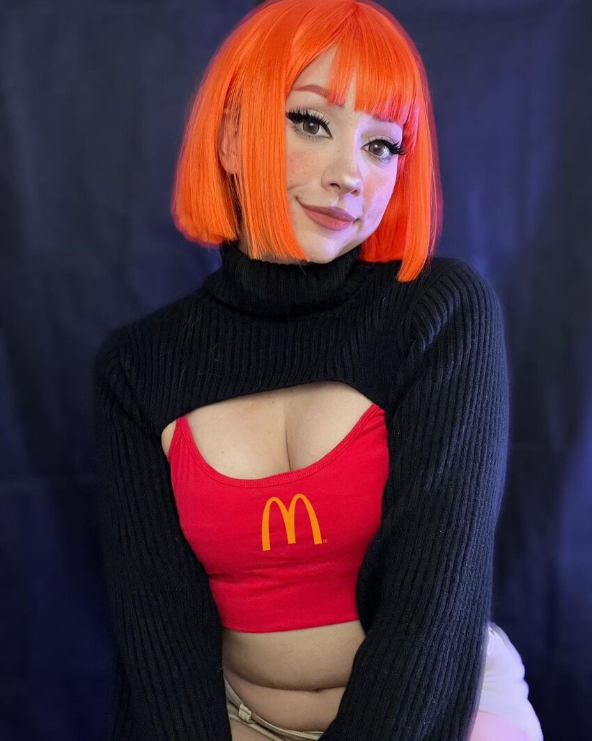 1girl black_background breasts brown_eyes cleavage cosplay female_focus highres indoors looking_at_viewer mcdonald&#039;s mexican_(nationality) mother_(yoru_mac) mother_(yoru_mac)_(cosplay) navel orange_hair photo_(medium) short_hair simple_background sitting small_breasts smile solo taliverse teeth yoru_mac