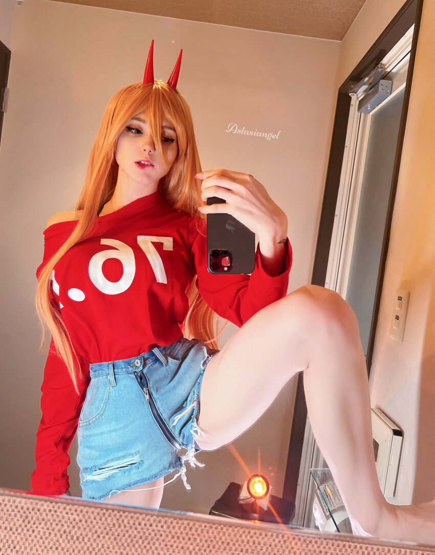 1girl ass astasiadream_(astasiangel) cellphone chainsaw_man cosplay female_focus highres horns jeans_shorts legs legs_apart long_hair long_legs orange_hair phone photo_(medium) power_(chainsaw_man) power_(chainsaw_man)_(cosplay) real_life shorts solo