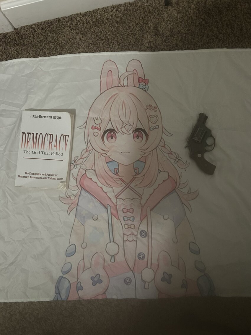 blanket book carpet gun handgun hans-hermann_hoppe highres hood hoodie indie_virtual_youtuber jacket open_clothes open_jacket pajamas phase_connect photo_(medium) pink_eyes pink_hair pipkin_pippa revolver weapon