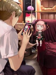  1boy 1girl anya_(spy_x_family) black_dress black_pants black_shoes blonde_hair blush cellphone cellphone_photo collarbone commentary couch dress english_commentary english_text feet_out_of_frame fingernails from_side full_body hair_ornament half-closed_eyes heart henoopd highres holding holding_phone holding_stuffed_toy looking_at_another medium_hair neck_ribbon on_couch pants phone photo_(medium) photo_background pink_hair ribbon shirt shoes short_hair short_sleeves sitting smartphone smile socks sparkle spy_x_family stuffed_toy t-shirt teeth twilight_(spy_x_family) white_shirt white_socks 