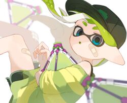  1girl bandaid bandaid_on_cheek bandaid_on_face bandaid_on_leg baseball_cap blue_eyes blurry blurry_background blurry_foreground commentary dolphin_shorts green_hair green_hat green_shirt green_shorts hat highres inkling inkling_girl inkling_player_character long_hair looking_at_viewer nintendo open_mouth pointy_ears print_hat sabata_saba shirt short_eyebrows shorts solo splat_bomb_(splatoon) splatoon_(series) splatoon_3 tentacle_hair thick_eyebrows 